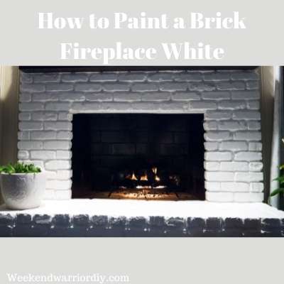 picture is a brick fireplace that has been painted white.